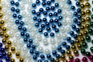 Macro view of bright colorful Mardi Gras beads with bokeh arranged in random fashion