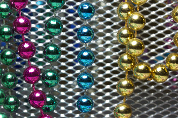 Macro view of bright colorful Mardi Gras beads with bokeh arranged in random fashion