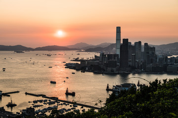 Fototapeta premium Stunning view of the sunset above the Victoria harbor in Hong Kong with the skyscraper of Kowloon Tsim Sha Tuis waterfront in the left in China