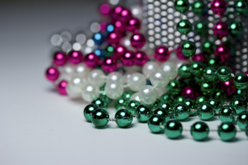 Macro view of bright colorful Mardi Gras beads with bokeh arranged in random fashion