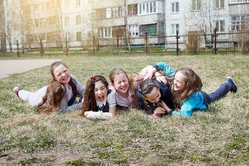 A group of children smile, have fun, lie on a green lawn. The concept of children's leisure, healthy lifestyle.