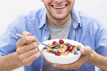 young man eating cereal with fruit