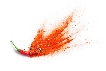 Chili powder and flakes burst out from red chili pepper
