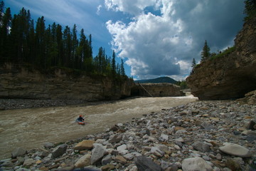 Murky river water in the Canadian Rocky mountains on a cloudy summer day 