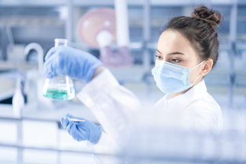 Female scientist looking at the sample in laboratory	