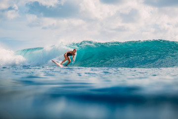 Surf girl on surfboard. Woman in ocean during surfing. Surfer and ocean