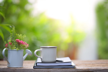Pink flower and white cup with notebook diary