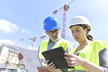 Construction manager and engineer working on building site