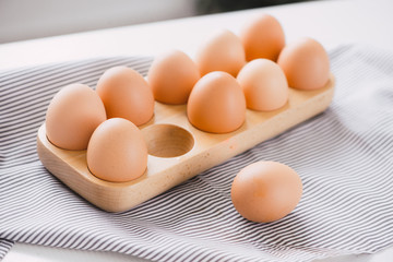 Raw chicken eggs in egg box on table.