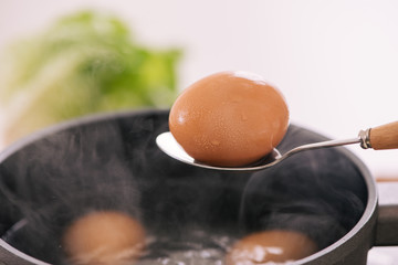Chef putting boiled eggs in cup / Cooking sweet brown Stewed pork gravy (Moo Pa-lo) concept