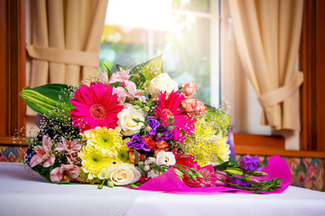 A magnificent bouquet of flowers on the table in the restaurant against the window. Flowers for birthday greetings. Festive bouquet of flowers. Flowers for a romantic mood