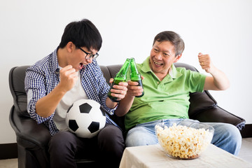 friendship, sports and entertainment concept - happy male friends cheering and watching tv together at home supporting world cup football team win