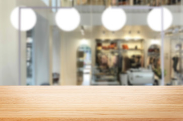 Obraz premium Selected focus empty brown wooden table and Coffee shop or restaurant blur background with bokeh image. for your photomontage or product display