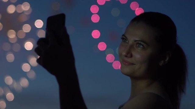 A girl uses a smartphone during a firework. slow motion. HD