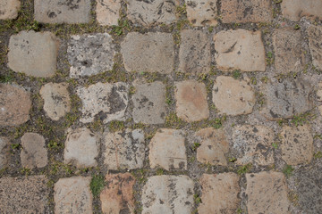 Abstract background of old cobblestone pavement tiled on all sides