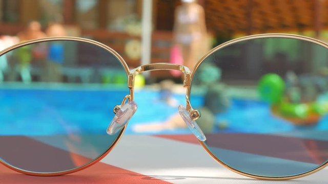 Sunglasses. Pool reflection. Concept of holiday at sea. Observations children, play.