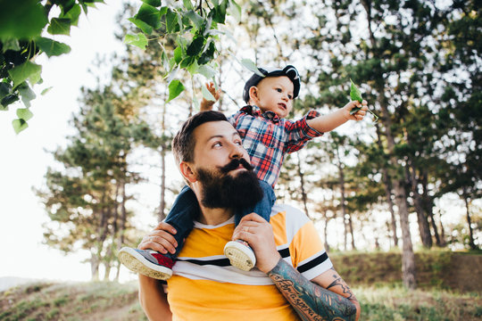 The hipster's father is playing with his little son.