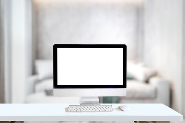 Mockup desktop computer on desk in living room background. white screen computer for graphic display montage