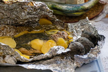 Baked salmon fish in foil. Tasty dish, cooked with potatoes and dill.