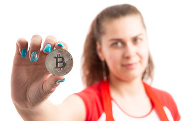 Young woman retailer or sales assistant holding bitcoin symbol.