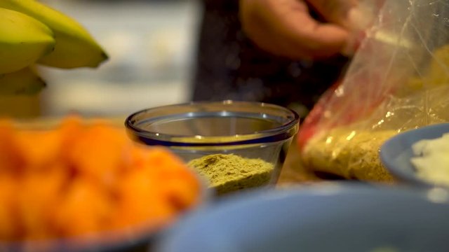 Close Up, Spices are measured and added to a glass bowl on a full kitchen table