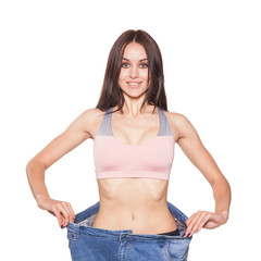 Fototapeta premium A beautiful brunette model in sportswear shows the results of losing weight. Relief abdomen.