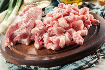 Raw pork belly pieces on a cutting board