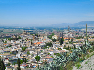 Albaicin, Old muslim quarter, white houses with orange tiling roofs, district of Granada in Spain. View from the top of Sacromonte mountain. Panorama.