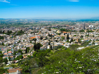 Albaicin, Old muslim quarter, white houses with orange tiling roofs, district of Granada in Spain. View from the top of Sacromonte mountain. Panorama.