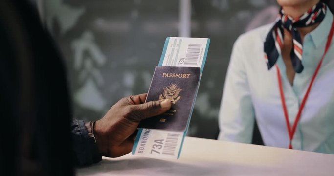 Flight passenger holding passport and boarding pass at airline desk