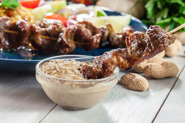 Traditional pork satay with peanut sauce and vegetables
