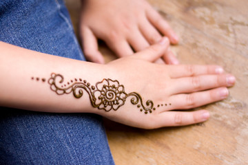 henna tattoo on small girl hand. Mehndi is traditional Indian decorative art. Close-up, overhead...