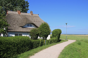 typisches Reetdachhaus direkt am Deich zwischen Bodden und Ostseeküste