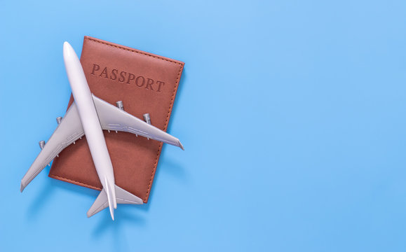 Toy plane on top of passport on blue copy space