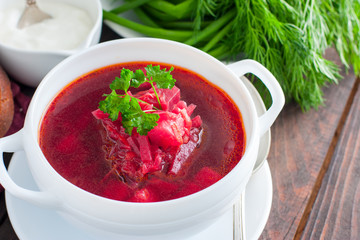 Traditional for Ukrainian and Russian cuisine vegetarian borscht in a white bowl, horizontal, copy space