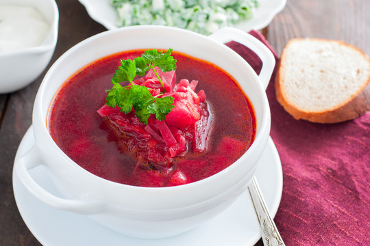 Ukrainian traditional borsch. Russian vegetarian red soup in white bowl on black background. Top view. Borscht, borshch with beet
