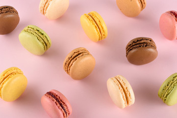 Original classic colorful french macarons assortment with different tastes on pink pastel background