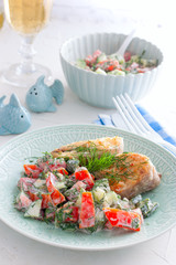 Fried fish with fresh tomato and cucumber salad, selective focus