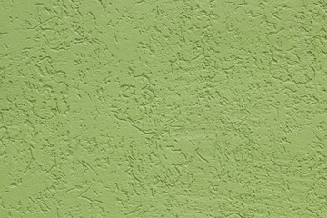 Green flat rough painted cement wall with many cavities. Seamless texture. Used as a background.