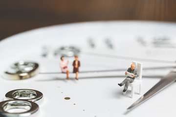 Miniature people Businessman sitting on clock , Concept of Time and Work  

