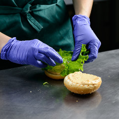 Unidentified chef preparing veggie burger with yummy vegetable p