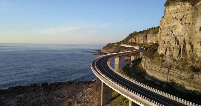 Driving along the Sea Cliff Bridge, south of Sydney in New South Wales, Australia. Coastal drive along a highway suspended over the coast line with mountains on one side and the ocean on the other.