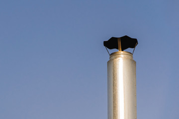 chimney made of stainless steel on a blue sky background