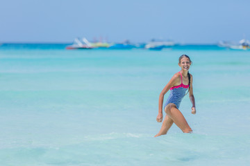 Girl in swimsuit runing and having fun on tropical beach