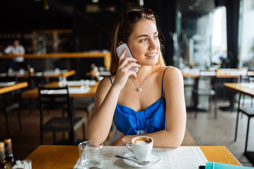 Beautiful woman in cafe using phone