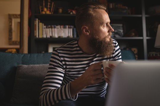 Thoughtful man having coffee at home