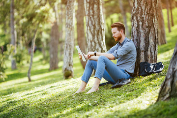Businessman using tablet in park