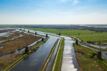 Fototapeta na wymiar Windmills and water canal in Kinderdijk in a beautiful spring da
