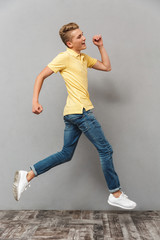 Full length portrait of a cheerful teenage boy running away