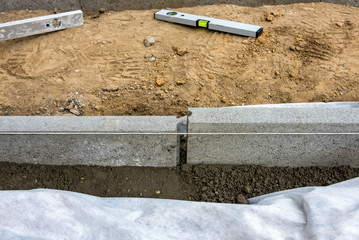 Setting of edge restraints with border stones in concrete